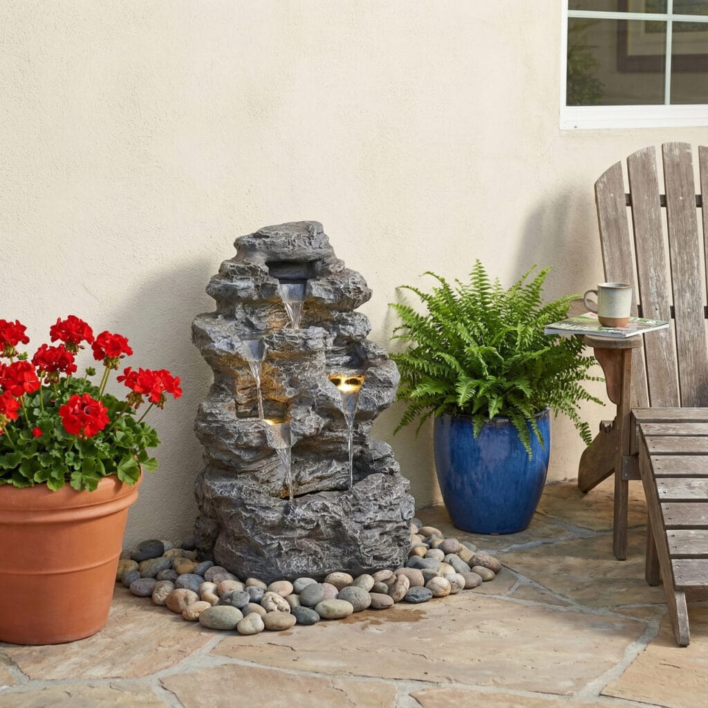 23.8 inch tall slim concrete outdoor water fountain placed in patio with lounge chair coffee and potted plants